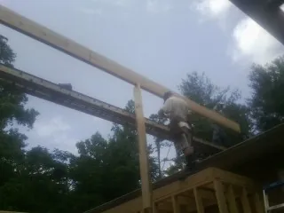 Carpenter setting a ridge beam over a new addition frame — Ice Dam Removal by Roofing Brothers in South Windham