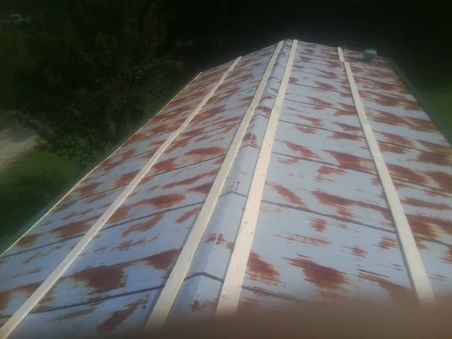 Rusted metal roof panels with new wood purlins before replacement — Storm Damage Roof Repair in South Windham by Roofing Brothers
