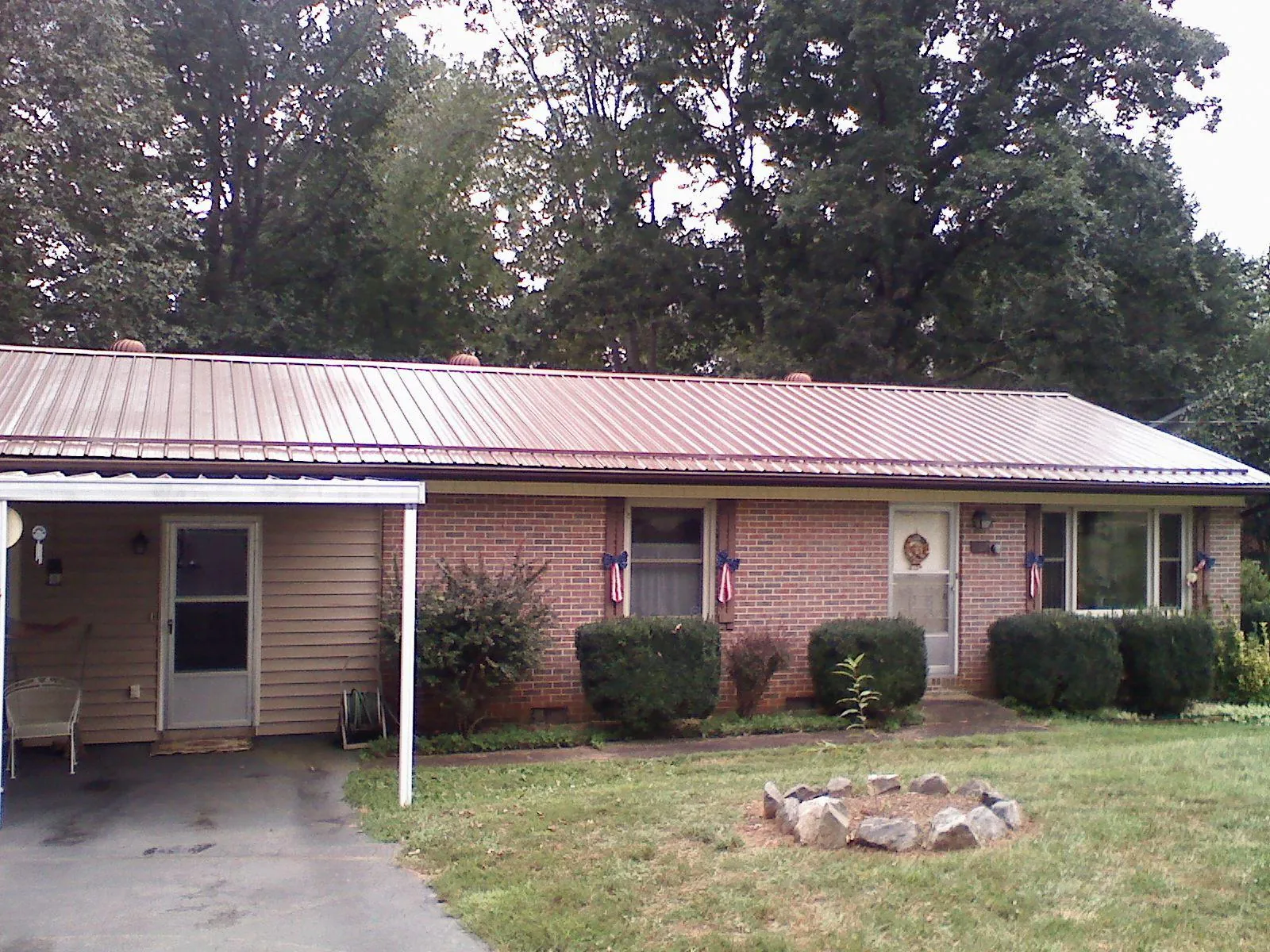 Bronze metal roof and carport on a brick ranch home — Roof Repair work by our crew in South Windham
